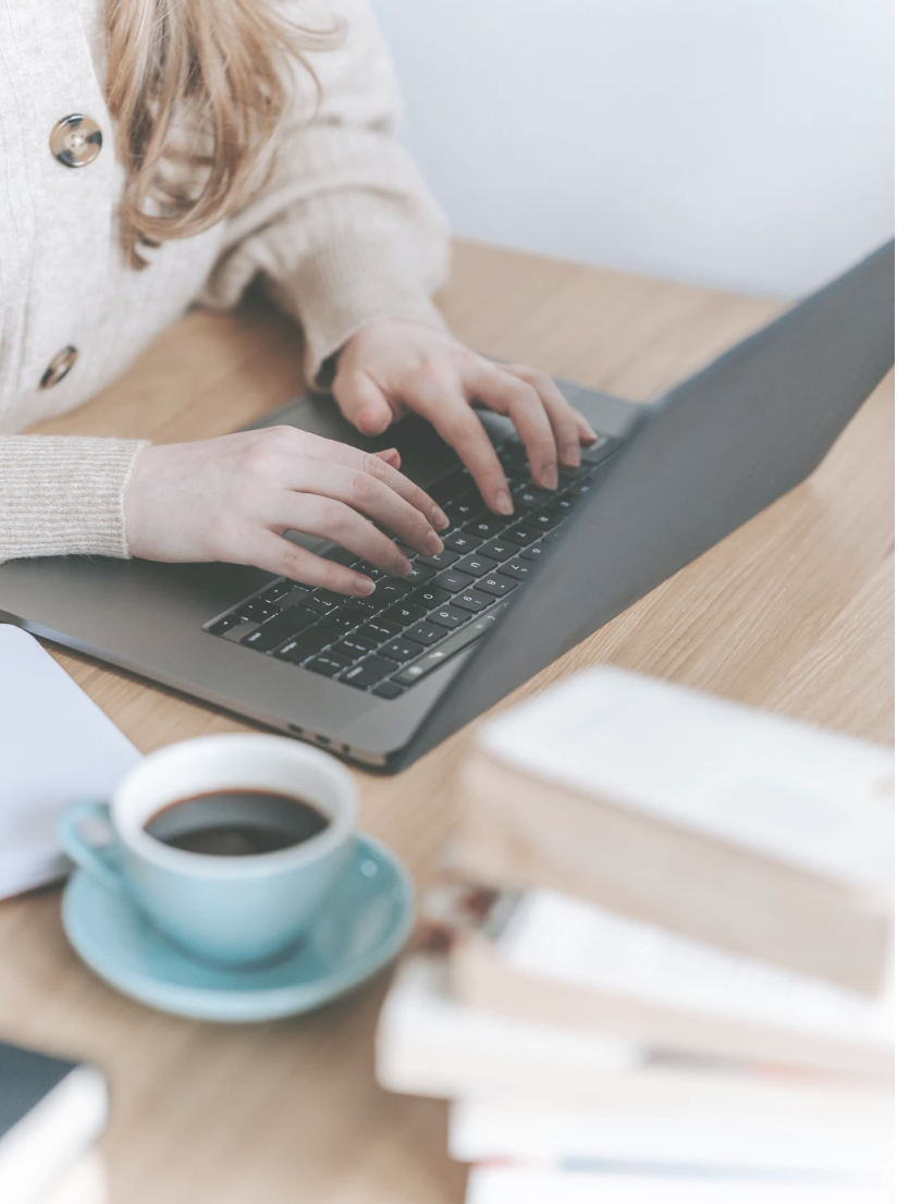 A woman writing her story on a laptop
